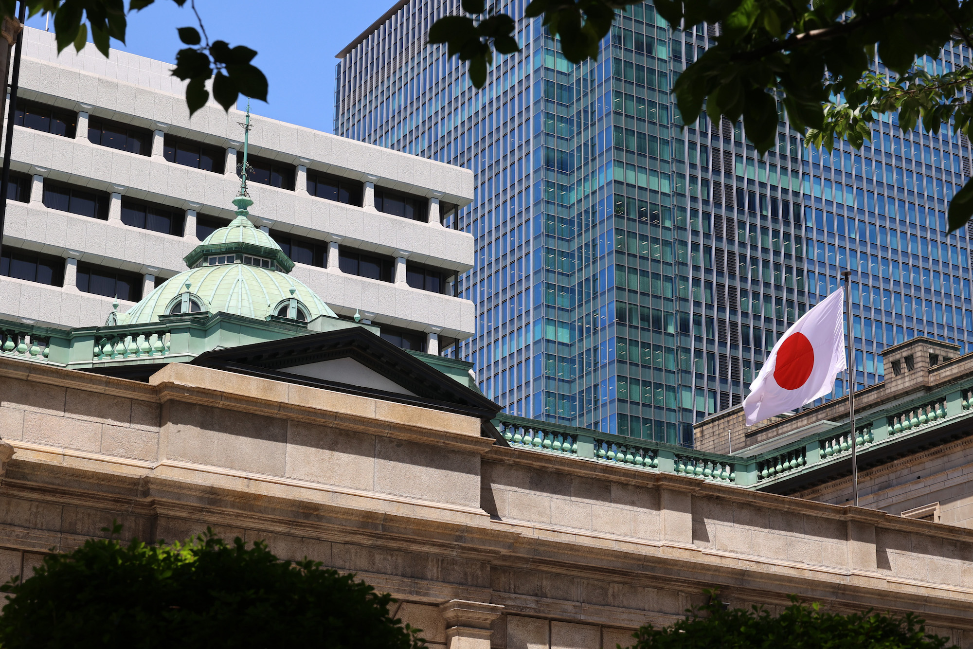 Bank of Japan building with the Japanese flag, highlighting its role in economic policies, rate decisions, and forex market trends.