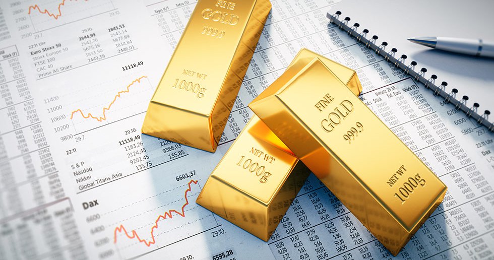 Three gold bars placed on financial charts with stock market graphs and data, symbolizing investment strategies and market analysis.